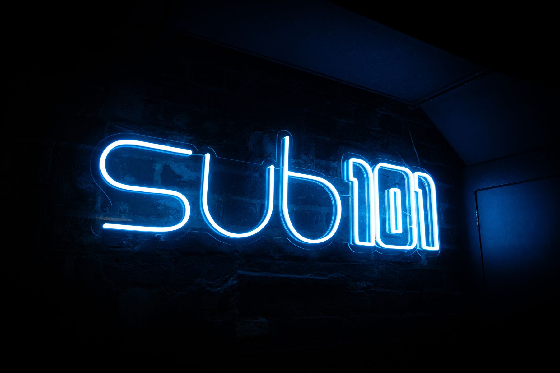The Sub 101 neon sign in the downstairs room at Cruz 101